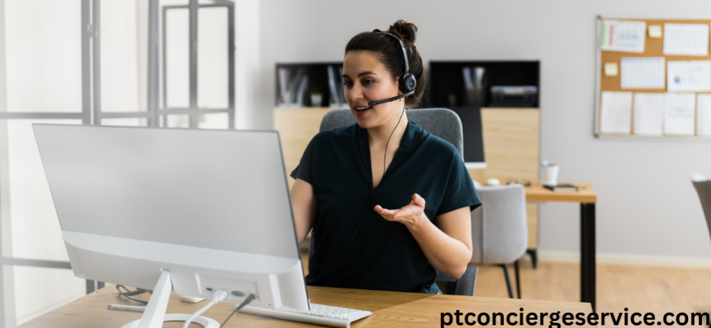 Virtual assistant sitting at a desk in front of computer talking on the phone